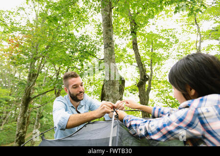 Freunde, die ein Zelt auf einem Campingplatz aufstellen Stockfoto