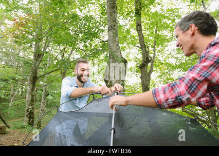 Freunde, die ein Zelt auf einem Campingplatz aufstellen Stockfoto