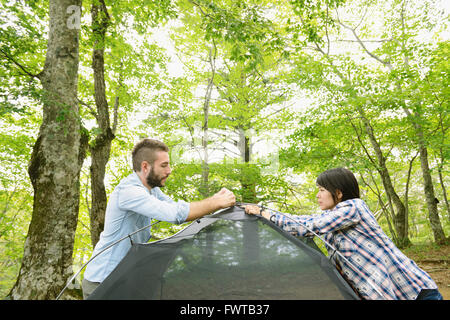 Freunde, die ein Zelt auf einem Campingplatz aufstellen Stockfoto