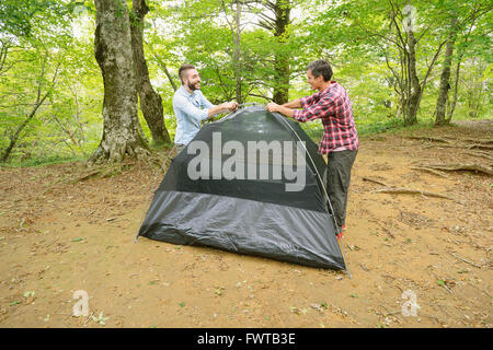 Freunde, die ein Zelt auf einem Campingplatz aufstellen Stockfoto