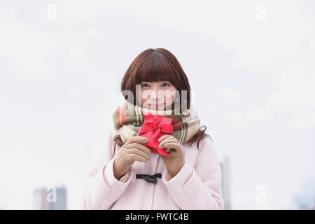 Attraktive Japanerin mit Geschenk an einem Wintertag Stockfoto