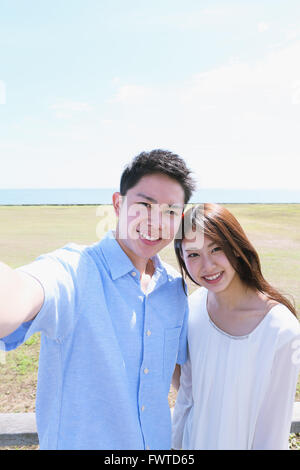Junge japanische paar nehmen Selfie am Meer Stockfoto
