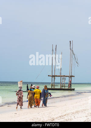 Einheimische Frauen gehe Fischen an einem Strand in Sansibar, Tansania. Stockfoto