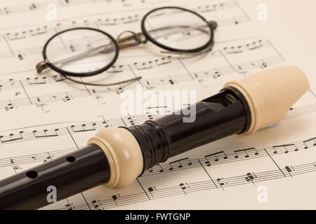 Ein musikalische Recorder platziert auf einige alte Noten und ein paar Vintage-Brillen - Studio gedreht Stockfoto