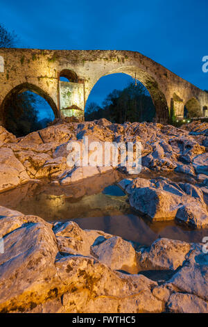 Nacht fällt auf die römische Brücke in Cangas de Onis Asturien, Spanien. Stockfoto