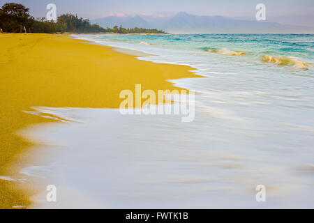 Wellen am Strand bei Sonnenaufgang am Baldwin Park, Maui Stockfoto