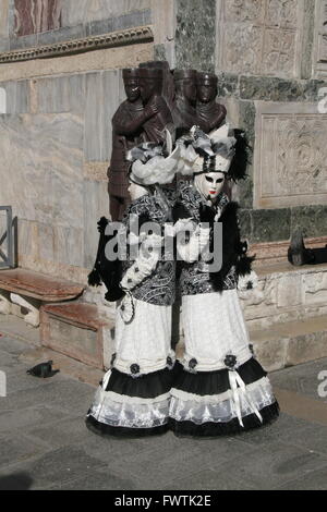 Maskierte Karneval Teilnehmer, posiert vor der Skulptur der vier Tetrarchen, Pizza San Marco, Venedig, Italien Stockfoto