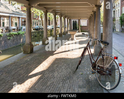 Fahrrad geparkt in alten Visbank Gouwe Canal in Gouda, Niederlande Stockfoto