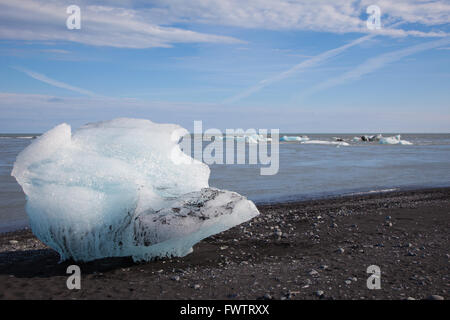 ein großer Teil der Gletschereis auf einem Lavastrand in Island gestrandet Stockfoto