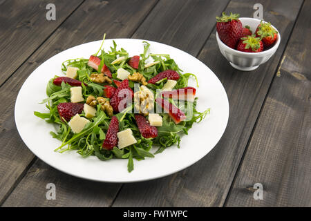 Frühlings-Salat mit Erdbeeren, Rucola, Parmesan-Käse, Walnüssen und Balsamico-Essig. Stockfoto