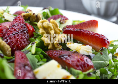 Frühlings-Salat mit Erdbeeren, Rucola, Parmesan-Käse, Walnüssen und Balsamico-Essig. Stockfoto