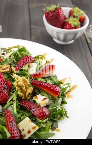 Frühlings-Salat mit Erdbeeren, Rucola, Parmesan-Käse, Walnüssen und Balsamico-Essig. Stockfoto