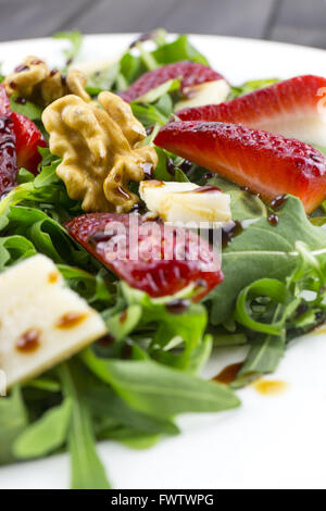 Frühlings-Salat mit Erdbeeren, Rucola, Parmesan-Käse, Walnüssen und Balsamico-Essig. Stockfoto