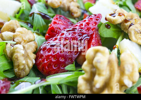 Frühlings-Salat mit Erdbeeren, Rucola, Parmesan-Käse, Walnüssen und Balsamico-Essig. Stockfoto