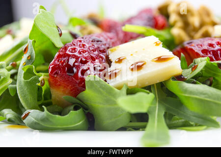 Frühlings-Salat mit Erdbeeren, Rucola, Parmesan-Käse, Walnüssen und Balsamico-Essig. Stockfoto