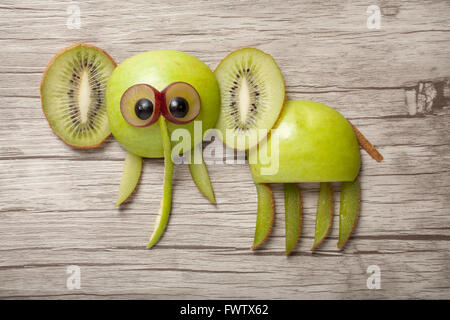 Elefant gemacht von Apfel und Kiwi am Schreibtisch aus Holz Stockfoto