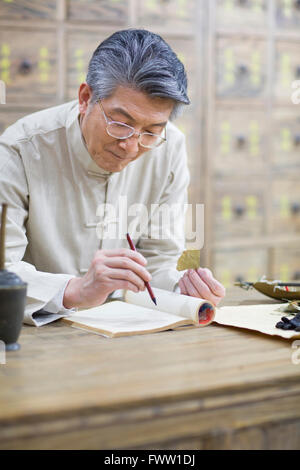 Senior-chinesischen Arzt Überprüfung Heilkräuter Stockfoto