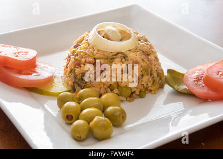 Kubanische Küche traditionelle kreolische gelbem Reis garniert mit Oliven, Zwiebeln, Tomaten und Pickels. Stockfoto