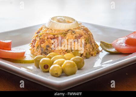 Kubanische Küche traditionelle kreolische gelbem Reis garniert mit Oliven, Zwiebeln, Tomaten und Pickels. Stockfoto