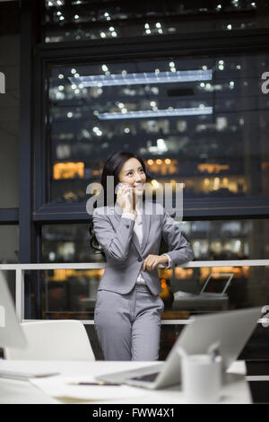 Geschäftsfrau, die das Telefonieren im Büro Stockfoto