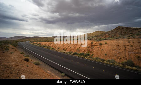 Schwarze Strang der Autobahn führt durch die roten Felsen Wildnis des südlichen Nevada. Stockfoto