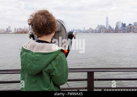 Sechs Jahre alter Junge mit Münzeinwurf Fernglas auf Liberty Island, New York, Vereinigte Staaten von Amerika. Stockfoto