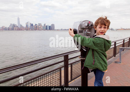 Sechs Jahre alter Junge mit Münzeinwurf Fernglas auf Liberty Island, New York, Vereinigte Staaten von Amerika. Stockfoto