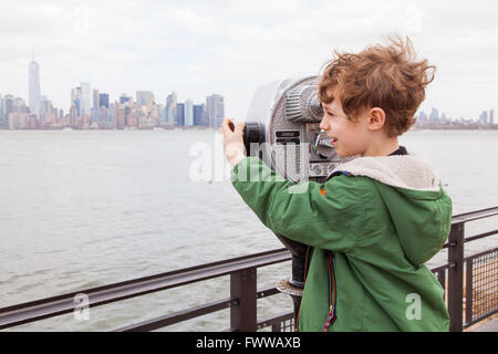 Sechs Jahre alter Junge mit Münzeinwurf Fernglas auf Liberty Island, New York, Vereinigte Staaten von Amerika. Stockfoto