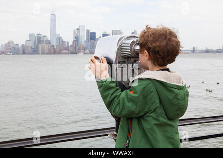 Sechs Jahre alter Junge mit Münzeinwurf Fernglas auf Liberty Island, New York, Vereinigte Staaten von Amerika. Stockfoto
