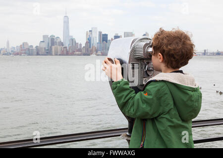 Sechs Jahre alter Junge mit Münzeinwurf Fernglas auf Liberty Island, New York, Vereinigte Staaten von Amerika. Stockfoto