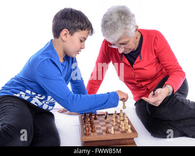 Oma mit ihrem Enkel, Schach zu spielen. weißen Hintergrund. Stockfoto