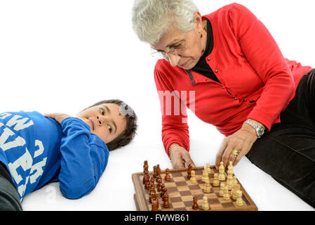 Oma mit ihrem Enkel, Schach zu spielen. weißen Hintergrund. Stockfoto