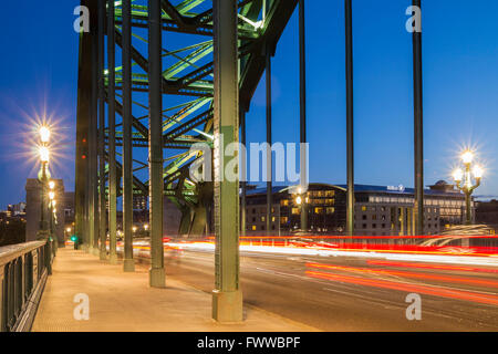 Auto leichte Wanderwege wie Verkehr die berühmte Tyne Bridge in Newcastle Upon Tyne, England, UK kreuzt. Hilton Hotel in Ferne Stockfoto