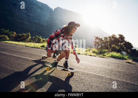 Junger Mann Longboarden im freien Landschaft unterwegs. Männlich, skateboarding an einem sonnigen Tag. Stockfoto