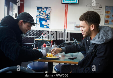 Zwei männliche Studenten Essen im Café
