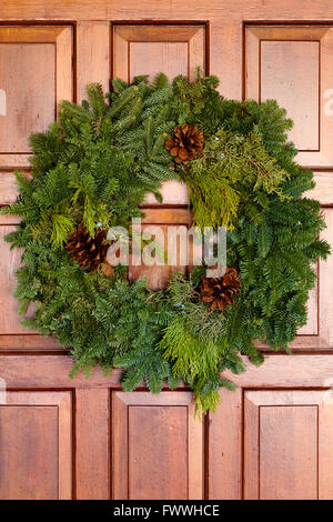 Grüne Weihnachtskranz hängen Holztür Stockfoto