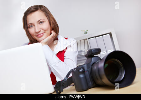 Glücklich Fotografin im Studio mit Kamera und Laptop computer Stockfoto