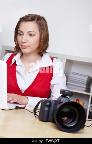 Professionelle Fotografin übertragen Bilder von DSLR-Kamera, Laptop-computer Stockfoto