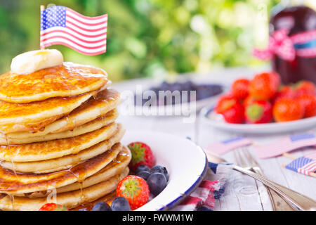 Ein Stapel hausgemachte Pfannkuchen mit frischem Obst, Butter und Sirup. Stockfoto