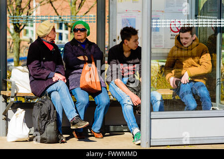 Simrishamn, Schweden - 1. April 2016: Menschen warten auf einen Bus in einer Wartehalle. Echte Menschen im Alltag. Stockfoto