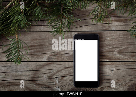 Smartphone mit leeren Bildschirm auf hölzernen Hintergrund Weihnachten Stockfoto
