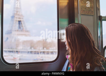 Touristen auf der Suche um den Eiffelturm durch das Fenster der Metro in Paris, lächelndes Mädchen besuchen Frankreich Stockfoto