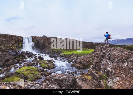 Backpacker Reisenden nehmen Foto des Wasserfalls mit Handy Stockfoto