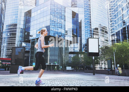 junge Frau läuft auf städtischen Hintergrund Stockfoto