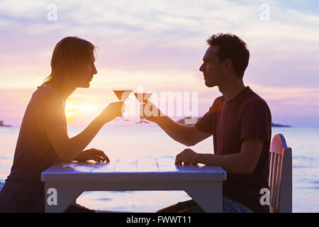 paar im Restaurant, tranken Cocktails am Strand bei Sonnenuntergang Stockfoto