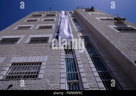 Jerusalem, Israel. April 2016. Ansicht eines Gebäudes mit der israelischen Flagge, die von jüdischen Siedlern erworben und als „Beit Yonatan“ bezeichnet wurde, das nach dem inhaftierten israelischen Agenten Jonathan Pollard im palästinensischen Viertel Silwan oder Siloam benannt wurde, das sich an den Hängen südlich der Altstadtmauern in Ostjerusalem Israel befindet Stockfoto