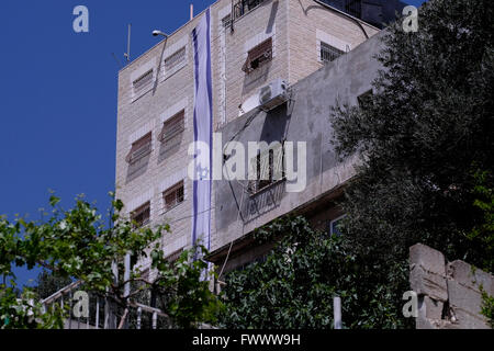 Jerusalem, Israel. April 2016. Ansicht eines Gebäudes mit der israelischen Flagge, die von jüdischen Siedlern erworben und als „Beit Yonatan“ bezeichnet wurde, das nach dem inhaftierten israelischen Agenten Jonathan Pollard im palästinensischen Viertel Silwan oder Siloam benannt wurde, das sich an den Hängen südlich der Altstadtmauern in Ostjerusalem Israel befindet Stockfoto