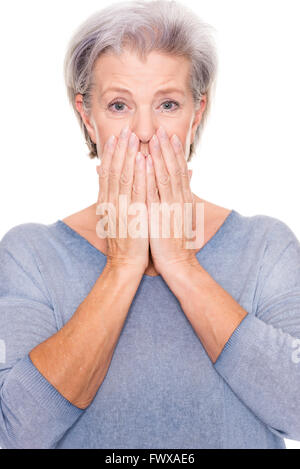 Ältere Frau erstaunt ist über etwas vor weißem Hintergrund Stockfoto