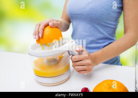 Nahaufnahme von Frau auspressen Orangensaft zu Hause Stockfoto