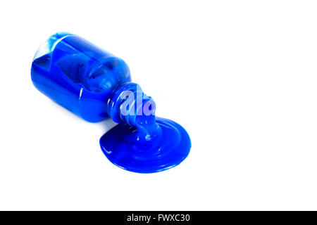 Blaue Farbe, die aus einer Flasche, isoliert auf weiss gießen Stockfoto